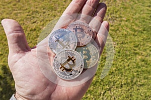 Cryptocurrency coins in a hand; Bitcoin