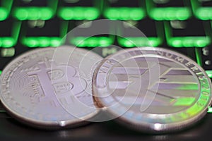 Cryptocurrency coins on illuminated computer keyboard