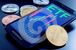 Stacked cryptocurrency coins and cell phone showing ETF message