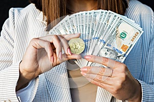 Cryptocurrency exchange. Joyful happy woman holding bitcoin and dollar banknotes closeup, digital money, electronic commerce