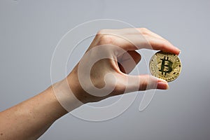 Cryptocurrency golden bitcoin coin. Hand holding symbol of crypto currency - electronic virtual money for web banking
