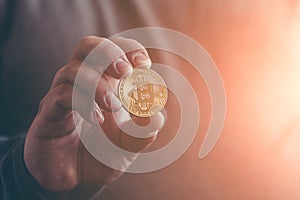 Cryptocurrency golden bitcoin coin in man hand