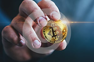 Cryptocurrency golden bitcoin coin in man hand - symbol of crypto currency - electronic virtual money photo