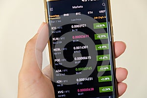 Cryptocurrency market graph screen on smartphone buy and sell button and hand with blur background. Blockchain , Fintech
