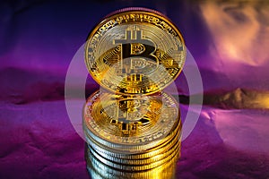 Cryptocurrency physical golden bitcoin coin on colorful background