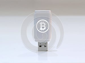 Cryptocurrency private key with glowing Bitcoin logo - USB Flash drive on white surface