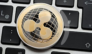 Cryptocurrency Ripple coin on computer laptop keyboard.