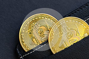 Cryptocurrency wallet, Bitcoin symbol sticking out of black wallet, beautiful black background, virtual currency, copy space