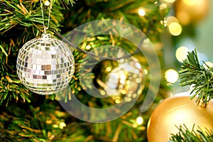 Crystal ball and golden Christmas Balls Decorated on Pine Tree on Christmas day with blurry background