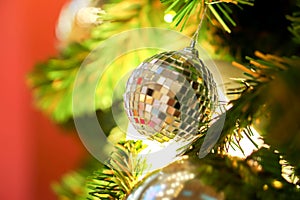 Crystal ball and golden Christmas Balls Decorated on Pine Tree on Christmas day with blurry background of Christmas tree