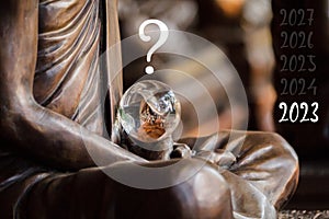 Crystal ball in the hands of a monk surmounted by a question mark, predicting the future