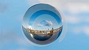A crystal ball with image of a city and blue sky in the background.