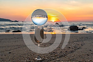 A crystal ball rests on the sandy pebbles of Kalim Beach.
