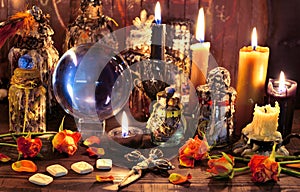 Crystal ball with runes, black candle and witch magic bottle