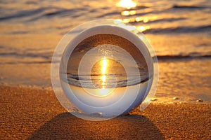 Crystal ball on the sand on the beach at sunset