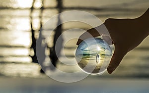 Crystal ball in the sea reflection on couple kissing