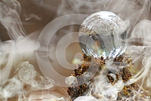 A crystal ball in the smoke. A magical accessory in the woods on