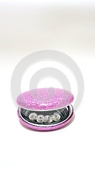 Crystal beads in a pink mirror shell. Horizontal image. White background.