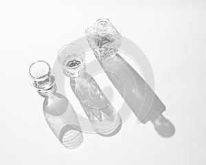 Crystal bottle and two glasses with long shadows. Black and white composition