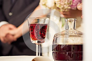 a crystal bottle of wine and a crystal glass for a wedding ceremony in a church