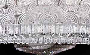 Crystal chandelier with elements in the form of shell flaps and faceted round suspensions