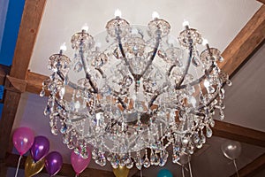 Crystal chandelier hanging on the ceiling . Large crystal chandelier with pendants in ceiling. Luxurious round lamp in their glass