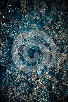 Crystal clear blue water in a mountain stream. A photo from the top of the detail. Top view.