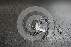 Crystal clear ice cube on grey table. Space for text