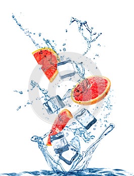 Crystal clear ice cubes, grapefruit and splashing water background