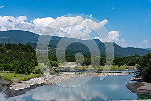 Crystal clear lake with trees and mountains in background