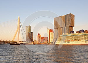 The crystal clear morning overshines the bridge, the skyscrappers and the moored cruise liner in Rotterdam, Netherlands photo
