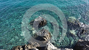 Crystal clear ocen water with volcanic rocks visible on the bottom