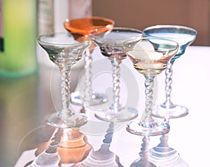 Crystal colorful stemware set with reflection on a table. Colourful elite set of empty alcohol liquor glasses