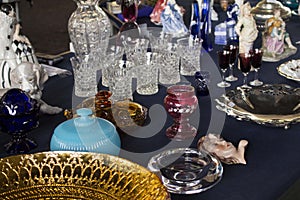 Crystal cups, glasses, plates, porcelain, pottery and other things displayed at a flea market