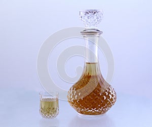 Crystal decanter and small glass filled with a golden liquid