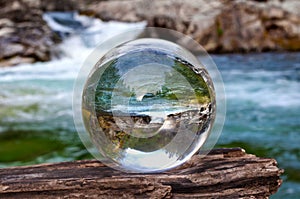 Crystal glass ball sphere reveals waterfall landscape