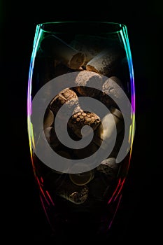 Crystal glass vase with stoppers from wine bottles on a dark background color of the rainbow