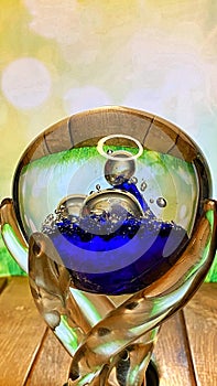 A crystal goblet stands on an oak table