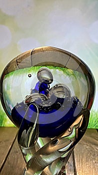 A crystal goblet stands on an oak table