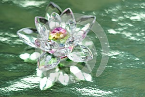 Crystal lotus on shiny green background with light reflection. Anahata chakra symbol. Esoteric, reiki energy, meditation