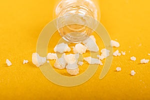 Crystal mephedrone designer drugs, bath salt on yellow background