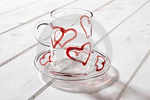 Crystal Mug and Saucer with Red Hearts Over Wooden Panel