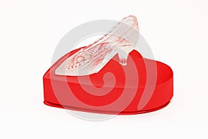 Crystal shoe on a red gift box in heart shape
