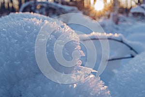 Crystal snow closeup. Snow in the sunset. Cold frosty day blurry background with snow texture in winter sun beams