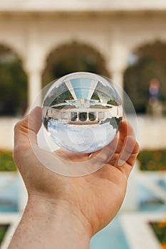 A crystal sphere held up in a garden