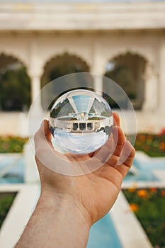 A crystal sphere held up in a garden