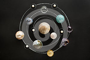 Crystal stones set in the form of a planetary system on black background. Round gemstones as planets on dark background