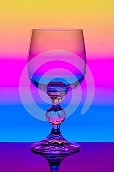 Crystal wine glass on a background of colored gradient