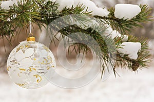 Crystalline Christmas tree ball on a snow-covered tree branch