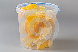 Crystallized honey in open plastic container on a gray background